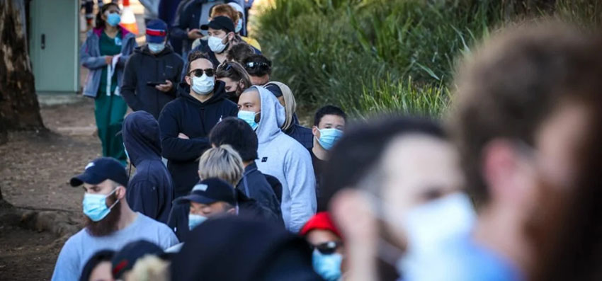 Tradesmen and women stand in a line wearing face masks as they wait to be vaccinated at the Sydney Olympic Park Vaccination Centre at Homebush in Sydney recently. Even as NSWcase numbers rise alarmingly, six million vaccinations have been conducted in the state.