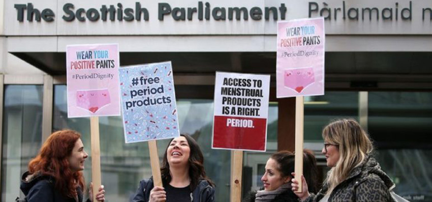 Scottish women holding placards demanding "menstrual rights" to free period products