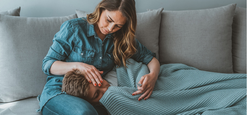 Woman stroking forehead of person suffering long covid