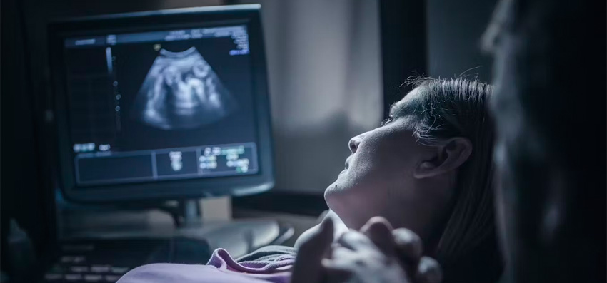 expectant mother watching ultrasound of baby