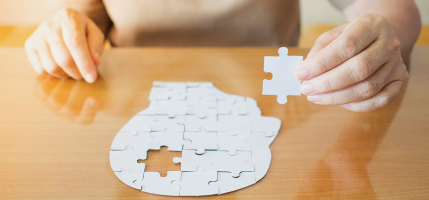 Dementia & MHT – Cause or correlation? Women placing final piece into jigsaw puzzle
